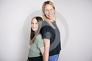 Beautiful pre teen girl with mother on studio white background