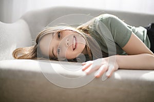 Beautiful pre teen girl relaxing on the sofa at home