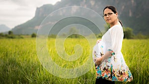 Beautiful Pregnant Asian Woman in Rice Field