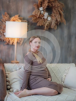 Beautiful pregnant blonde woman resting at home