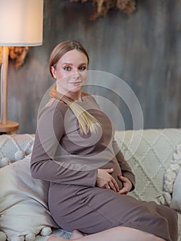 Beautiful pregnant blonde woman resting at home