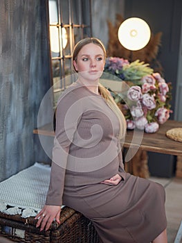 Beautiful pregnant blonde woman resting at home