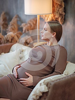 Beautiful pregnant blonde woman resting at home