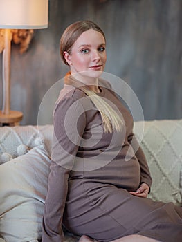 Beautiful pregnant blonde woman resting at home