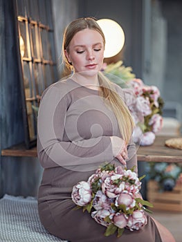 Beautiful pregnant blonde woman resting at home