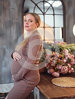 Beautiful pregnant blonde woman resting at home