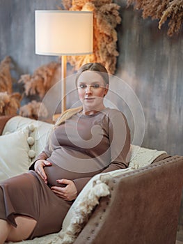 Beautiful pregnant blonde woman resting at home