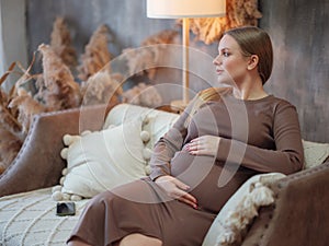 Beautiful pregnant blonde woman resting at home