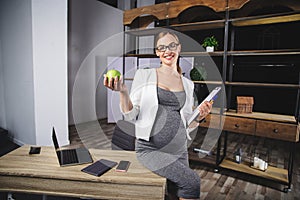 Pregnant mature businesswoman working at office