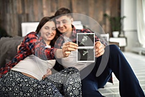 Beautiful pregnant couple in the bedroom. Preparing for childbirth, happy parents, waiting for the first child. Support