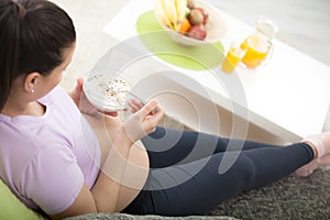 Beautiful pregnant girl having breakfast