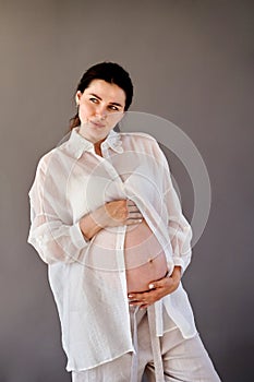 beautiful pregnant girl in a shirt with a bare stomach