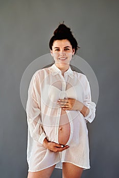 beautiful pregnant girl in a shirt with a bare stomach.