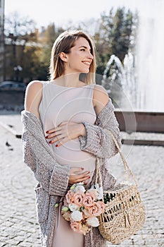 Beautiful pregnant girl walking the fountain