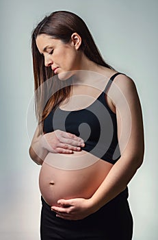 Beautiful pregnant looking her belly isolated