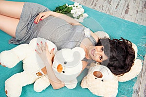 Beautiful pregnant mother with teddy bears