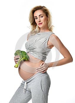 Beautiful pregnant woman big belly holding broccoli Pregnancy motherhood expectation healthy eating