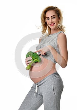 Beautiful pregnant woman big belly holding broccoli Pregnancy motherhood expectation healthy eating