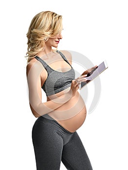 Beautiful pregnant woman with big belly use pregnancy motherhood expectation application typing on digital tablet pad