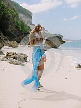 Beautiful pregnant woman in boudoir dress expecting baby at beach