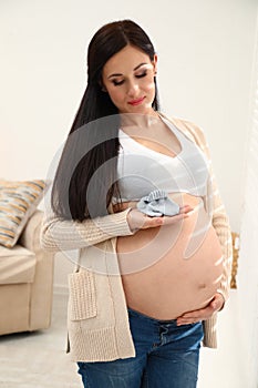 Beautiful pregnant woman with cute baby socks