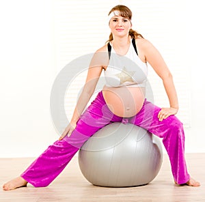 Beautiful pregnant woman doing exercises on ball