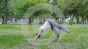 Beautiful pregnant woman doing prenatal yoga on nature outdoors. Sport, fitness, healthy lifestyle while pregnancy