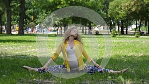 Beautiful pregnant woman doing prenatal yoga on nature outdoors. Sport, fitness, healthy lifestyle while pregnancy