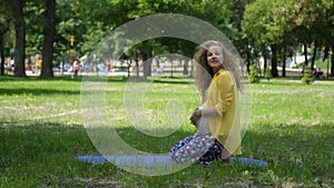 Beautiful pregnant woman doing prenatal yoga on nature outdoors. Sport, fitness, healthy lifestyle while pregnancy