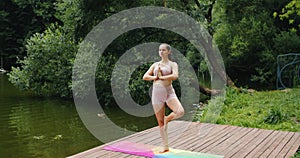 Beautiful pregnant woman doing prenatal yoga on nature outdoors. Sport, fitness, healthy lifestyle while pregnancy