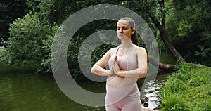 Beautiful pregnant woman doing prenatal yoga on nature outdoors. Sport, fitness, healthy lifestyle while pregnancy