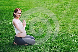 Beautiful pregnant woman doing prenatal yoga on nature outdoors.