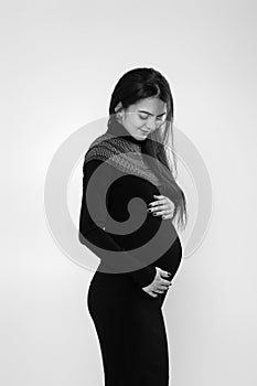 beautiful pregnant woman in dress holding her belly