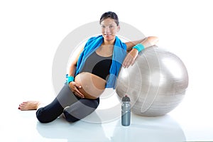 Beautiful pregnant woman at fitness gym relaxed