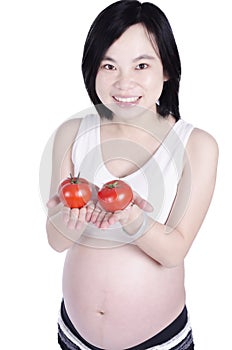 Beautiful pregnant woman with fresh tomato