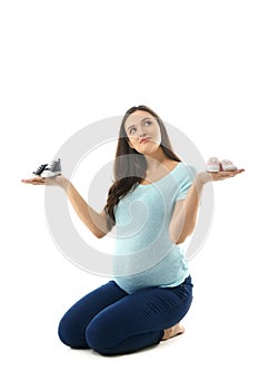 Beautiful pregnant woman with girlish and boyish booties on white background