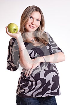 Beautiful pregnant woman with green apple