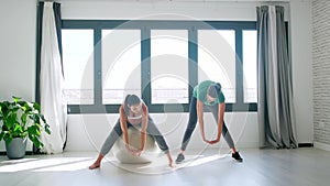 Beautiful pregnant woman with her physiotherapist doing pilates exercises preparing for childbirth.