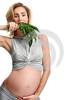 Beautiful pregnant woman hold organic dill for salad. Pregnancy motherhood expectation healthy eating