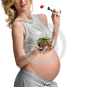 Beautiful pregnant woman hold organic salad and fork with tomato. Pregnancy motherhood expectation healthy eating