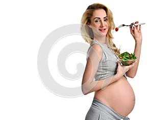 Beautiful pregnant woman hold organic salad and fork with tomato. Pregnancy motherhood expectation healthy eating