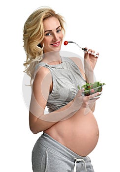 Beautiful pregnant woman hold organic salad and fork with tomato. Pregnancy motherhood expectation healthy eating