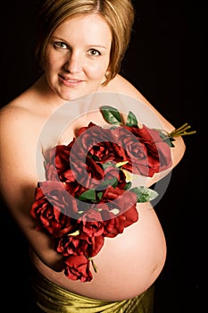 Beautiful pregnant woman holding flowers