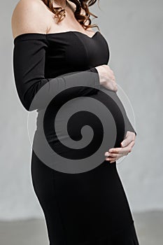 Beautiful pregnant woman hugging her belly. Expectant mother waiting for baby birth during pregnancy