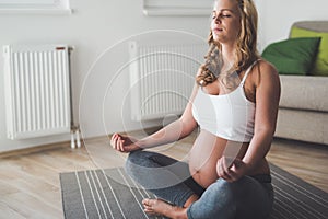 Beautiful pregnant woman in lotus yoga relaxing