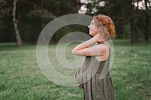 A beautiful pregnant woman outdoors, happily expecting a baby and a happy time of pregnancy