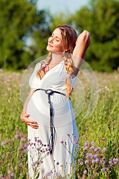 Beautiful pregnant woman relaxing in the park