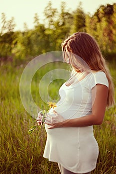 Beautiful pregnant woman relaxing in the park