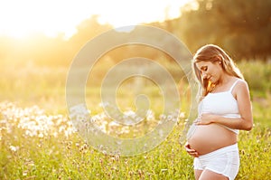 Beautiful pregnant woman relaxing in the park