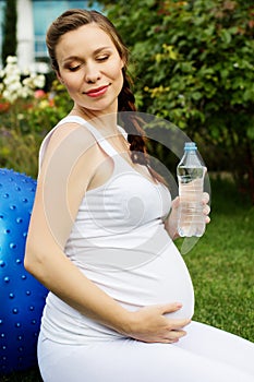 Beautiful pregnant woman relaxing in the park